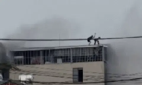 CLIP: Cận cảnh khoảnh khắc nghẹt thở khi 2 người đàn ông phá mái tôn mở đường sống trong đám cháy nhà 7 tầng ở Lĩnh Nam