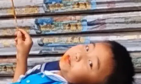 Mẹ đến đón muộn, cậu bé thản nhiên nằm trên bậc thềm ăn đồ ăn: Dân mạng bật cười vì quá chill!