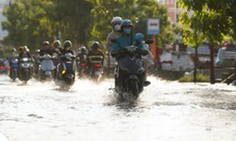 Triều cường dâng cao giữa trời nắng nóng, người dân TP.HCM bì bõm lội nước đi về